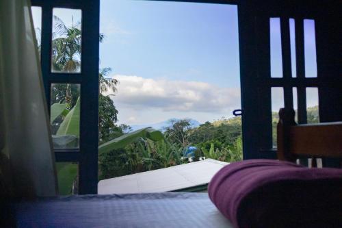 a room with a large window with a view of a golf course at Hogar na mata in Ubatuba