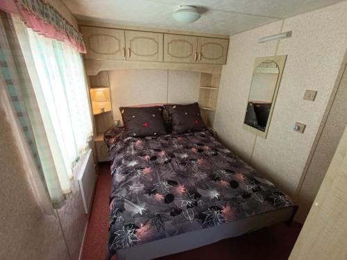 a small bedroom with a bed in a caravan at Nad Łabędzim Stawem in Dratów