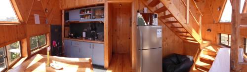 a kitchen with a refrigerator in a tiny house at Dune & Domes Pichilemu in Pichilemu
