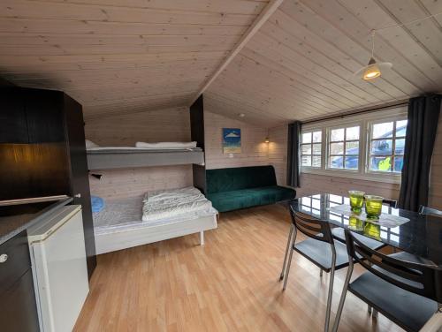 a living room with a table and a green couch at Tornby Strand Camping Cottages in Hirtshals