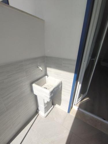 a bathroom with a white sink in a room at vinaka in SantʼAlessio Siculo
