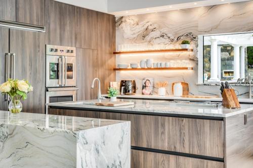 a kitchen with marble counter tops and wooden cabinets at Waterfront Lakehouse in New Fairfield