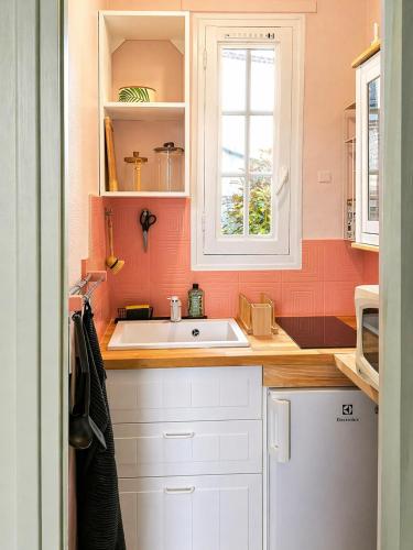 a kitchen with a white sink and a window at We Sea in Deauville