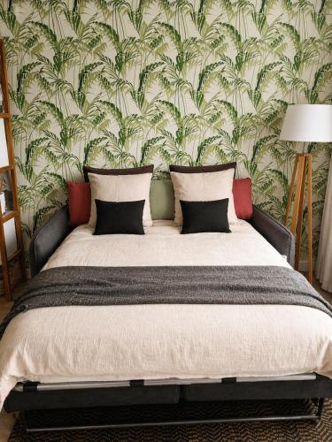 a bedroom with a large bed with a floral wallpaper at We Sea in Deauville