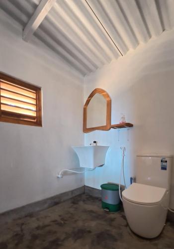 a bathroom with a toilet and a sink at Happy Hippy Beach Cabanas Peanut Farm in Panama
