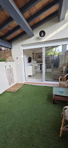 a living room with green carpet and a large window at Studio indépendant 2 personnes in Le Pradet