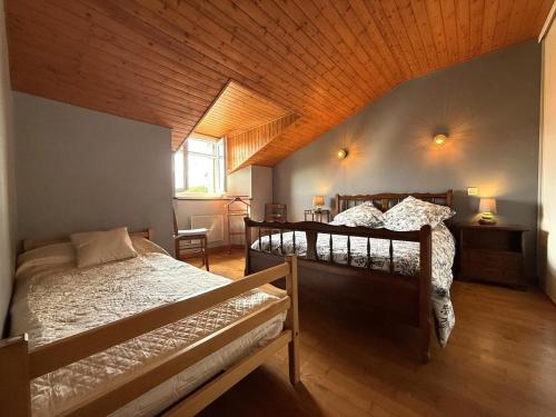 a bedroom with two beds and a wooden ceiling at Haramburua in Macaye