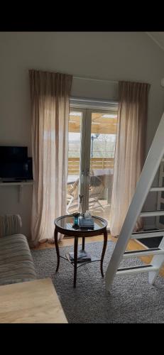 a living room with a table in front of a window at Flickan från havet Tiny House in Kode