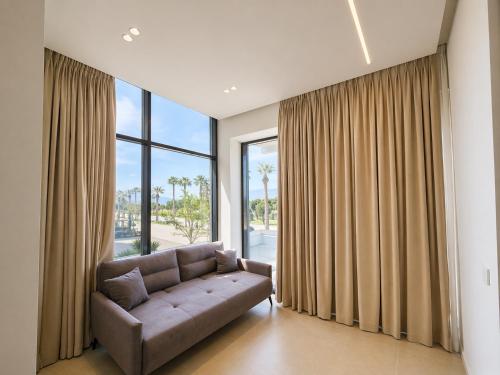 a living room with a couch and a large window at Suites By Jordan's Hotel in Vlorë