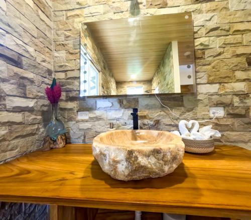 a bathroom with a large stone sink on a wooden counter at Red Frog Bungalows Ocean Resort in Short Cut
