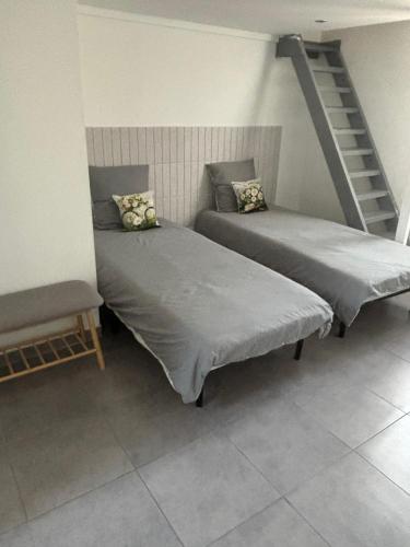 two beds in a room with a staircase at Chez Aurore in Port-de-Bouc