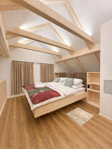 a large bed in a room with wooden floors at Bohinj Mountain Dreams in Bohinj