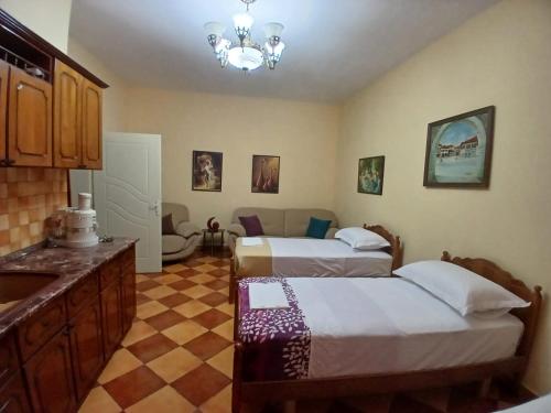 a bedroom with two beds and a checkered floor at Roland Palaj House in Shkodër