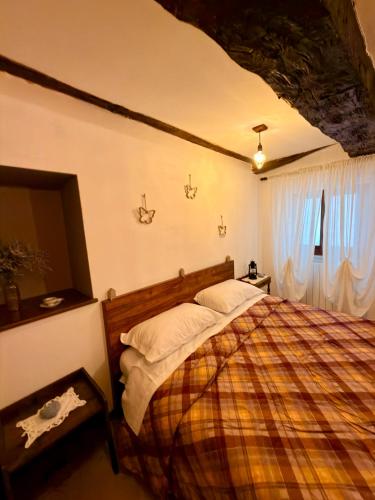 a bedroom with a bed with a plaid blanket at La Sibillina in Sarnano