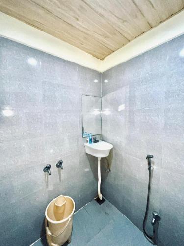 a bathroom with a sink and a toilet at Hotel MK in Ratlām