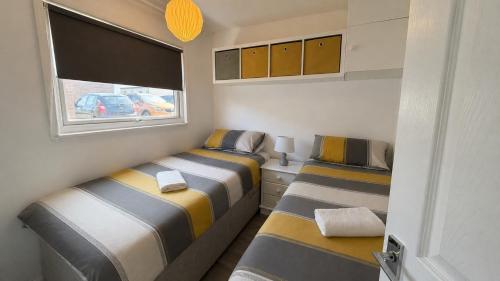 two beds in a small room with two windows at B by the sea in Scratby