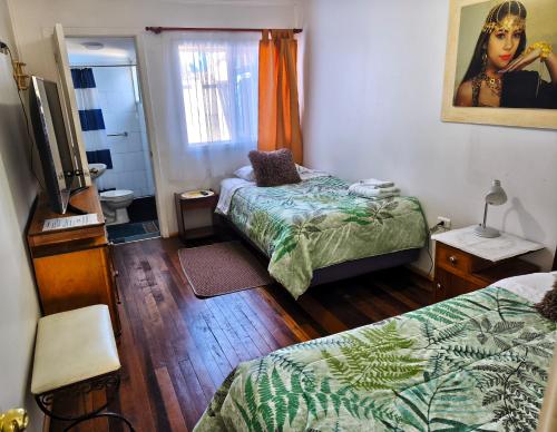 a small room with two beds and a mirror at Donde Mauricio in Coihaique