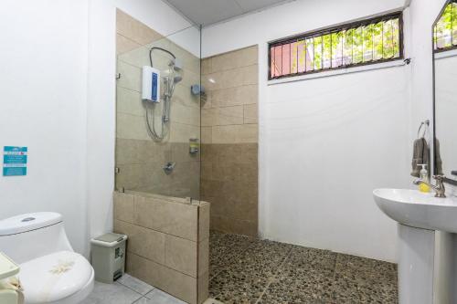 a bathroom with a shower and a toilet and a sink at Cahuita Apartment by Angie in Cahuita