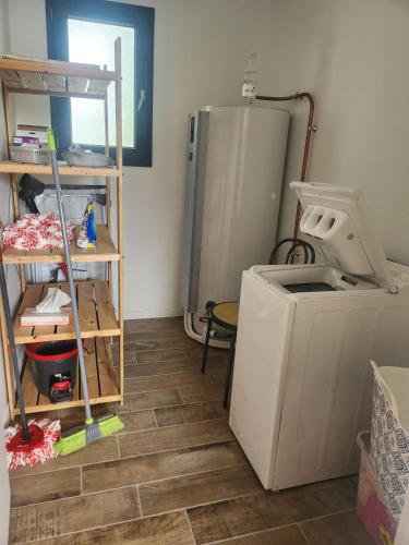 a kitchen with a washing machine and a refrigerator at Maison centre-ville , pisicne in Mimizan