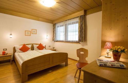 a bedroom with a bed and a table and a table sidx sidx sidx at Alpin Apartments Colfosco in Colfosco
