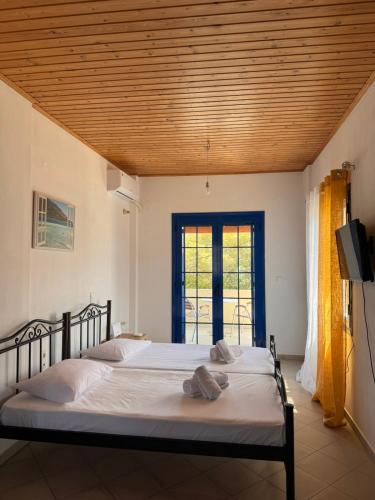 a bedroom with a bed and a television and a window at LifeHouse in Agia Pelagia
