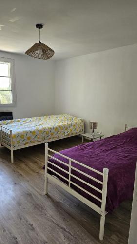 a bedroom with a large bed with purple sheets at La bâtisse a deux tours in Lalbenque
