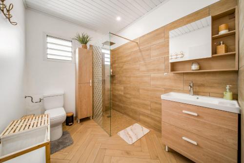 a bathroom with a toilet and a sink and a shower at Villa BELLEVUE in Bras-Panon