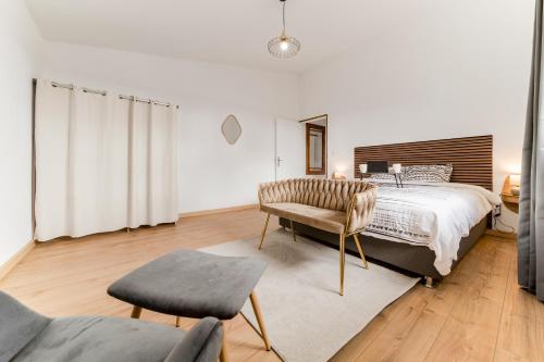 a bedroom with a large bed and a chair at Villa BELLEVUE in Bras-Panon