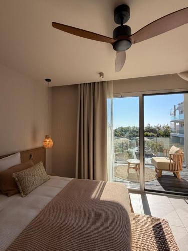 una camera da letto con un letto con ventilatore a soffitto e un patio di Hôtel Casa C a Propriano