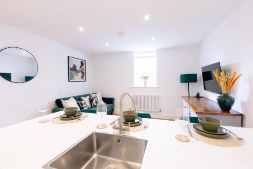 a kitchen with a sink and a living room at The Spa Town Loft in Buxton