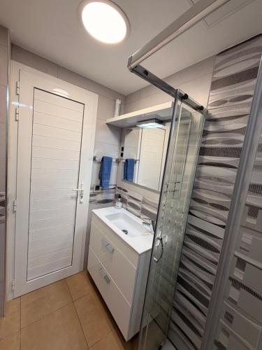 a bathroom with a sink and a glass shower at Villa Feliz 44 in Meloneras