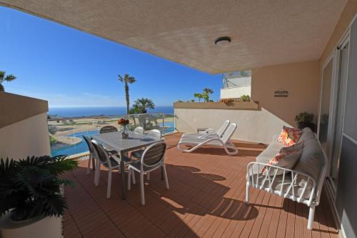 a patio with a table and chairs and the ocean at Hal Saghtrija - Gozo Hideaways in Żebbuġ