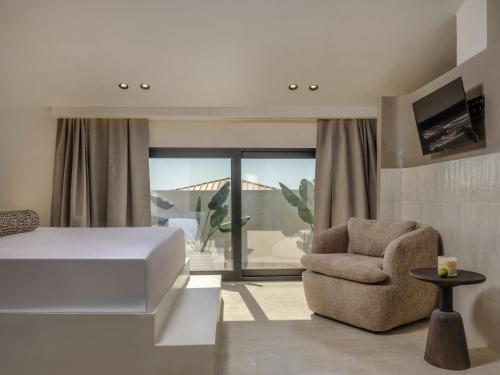 a bedroom with a bed and a chair at Blush - Crema - Leopard Apartments in Zakynthos