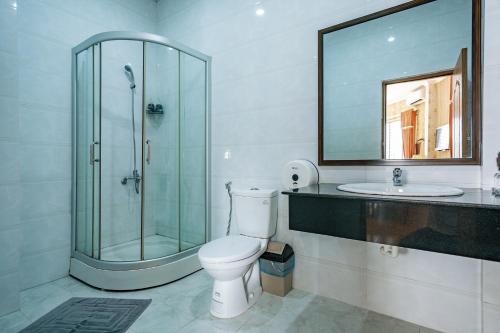 a bathroom with a shower and a toilet and a sink at Khách Sạn Long Xuyên in Long Xuyên