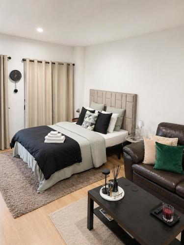 a bedroom with a large bed and a couch at Quarto Premium em Casa Moderna - Conforto & Design in São João da Talha