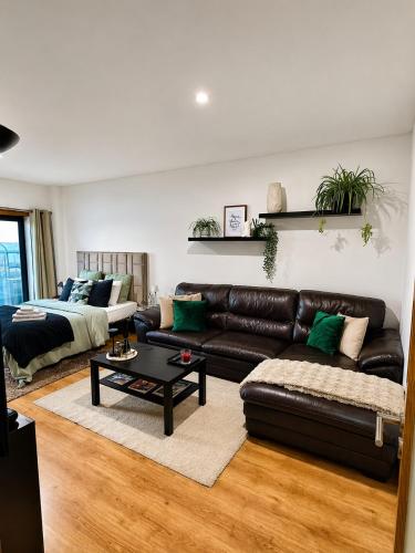 a living room with a leather couch and a coffee table at Quarto Premium em Casa Moderna - Conforto & Design in São João da Talha