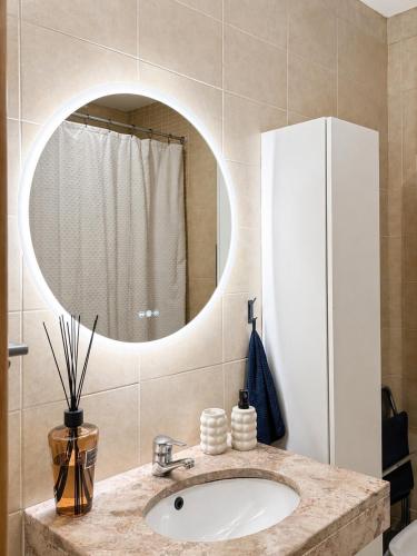 a bathroom with a sink and a mirror at Quarto Premium em Casa Moderna - Conforto & Design in São João da Talha