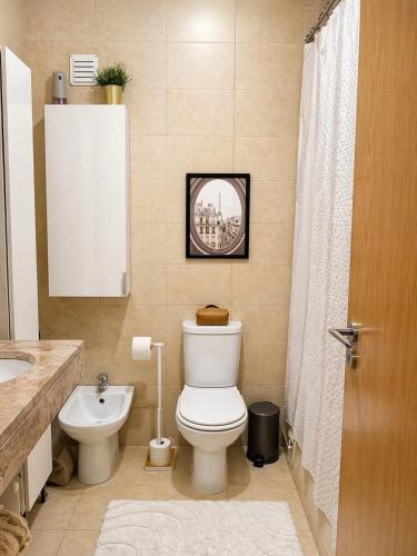 a bathroom with a toilet and a sink at Quarto Premium em Casa Moderna - Conforto & Design in São João da Talha