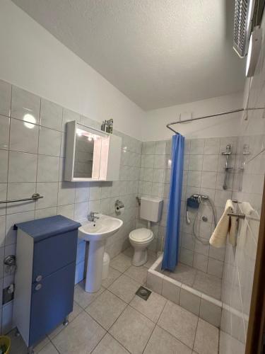 a bathroom with a sink and a toilet and a shower at Apartmani Lada 2 in Vrboska