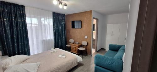 a bedroom with a bed and a blue couch at Vila Armonia in Curtea de Argeş