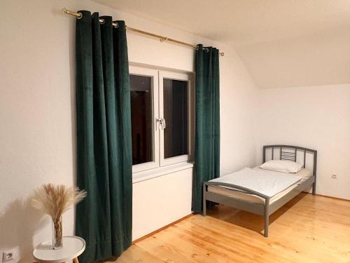 a bedroom with a bed and a window with green curtains at holiday home RIVER HOUSE in Jajce