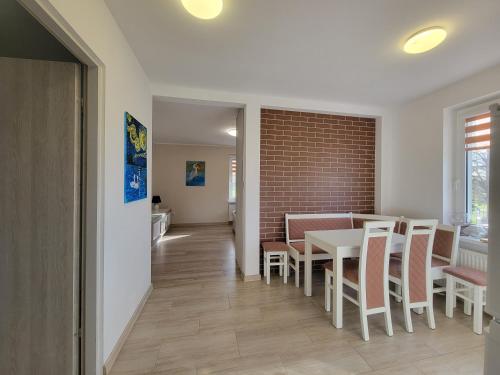 a dining room with a table and chairs and a brick wall at Apartament Harsz in Harsz