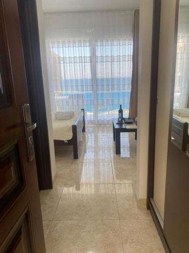 a hallway with a living room with a couch and a window at Apartmani Vila Delfin in Dobra Voda