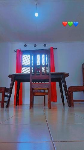 a dining room table with a wooden chair and balloons at Honeymoon villah in Diani Beach