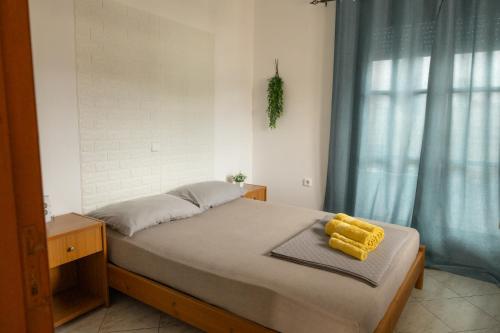 a bedroom with a bed with yellow objects on it at SteMaMaisonette in Afantou