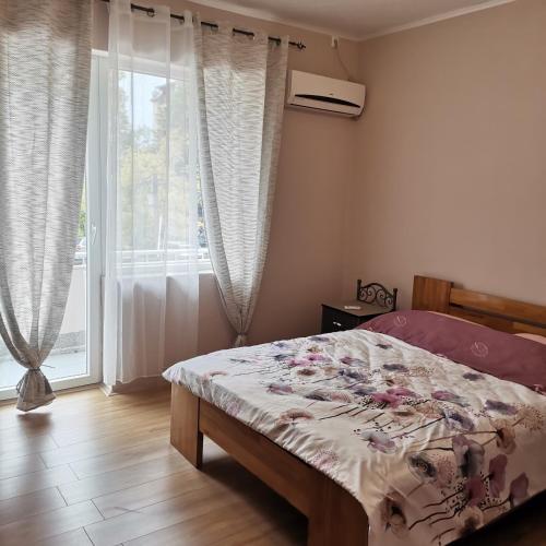 a bedroom with a bed and a large window at Zenith Apartment in Bitola