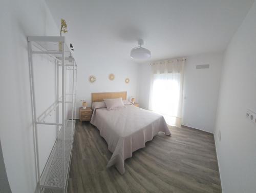 a white bedroom with a bed and a ladder at Casa Alba del Cabo in Los Albaricoques