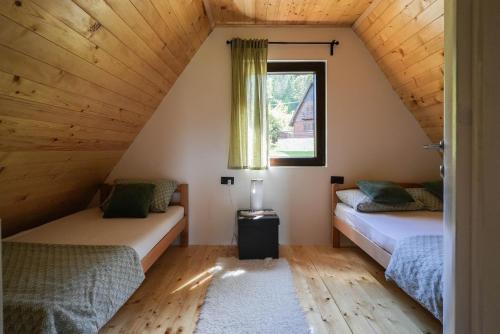 two beds in a attic room with a window at Josahouse in Bjeluša