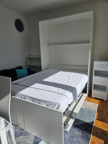 a bedroom with a white bed in a room at Port Dienville in Montfort-lʼAmaury