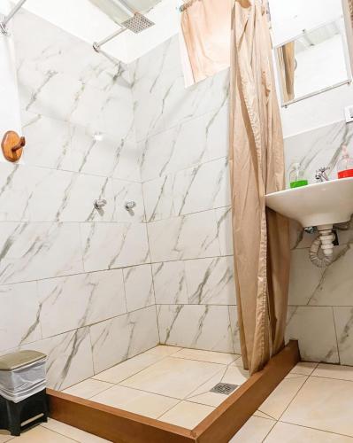 ein Badezimmer mit weißen Marmorwänden und einem Waschbecken in der Unterkunft Mindomundo Home in Mindo